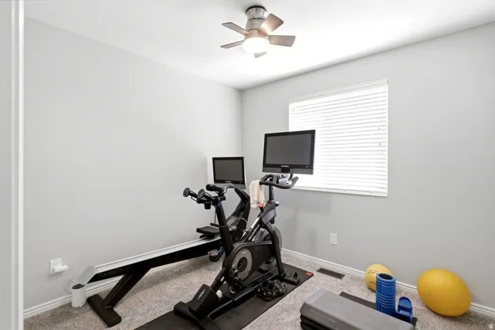Room featuring light gray walls, white trim, and a window with white blinds
