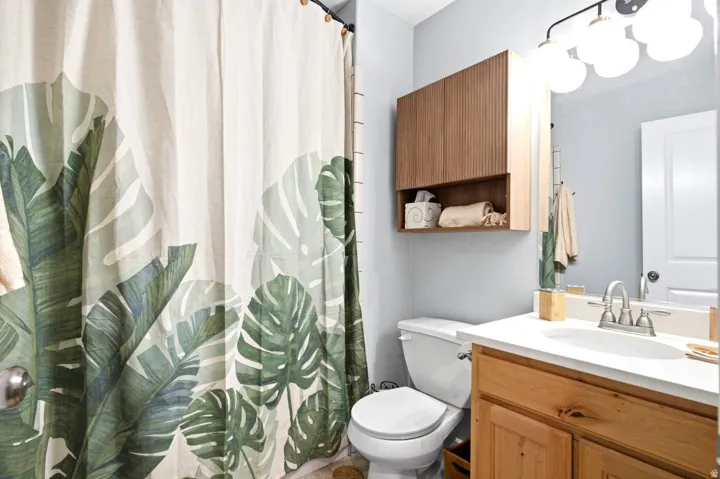 Bathroom featuring a light wood vanity, white countertop, and brushed nickel faucet