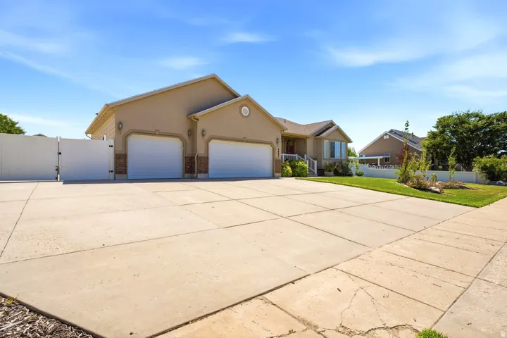 Expansive concrete driveway leading to a two-car garage