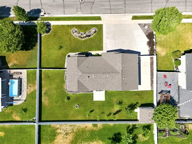 Expansive property featuring a spacious single-story residence, a substantial driveway, a manicured lawn, and a fenced perimeter