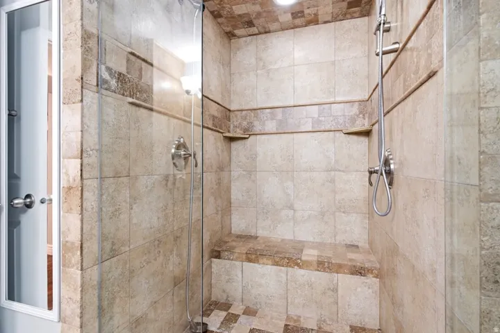 Spacious tile shower with clear glass enclosure