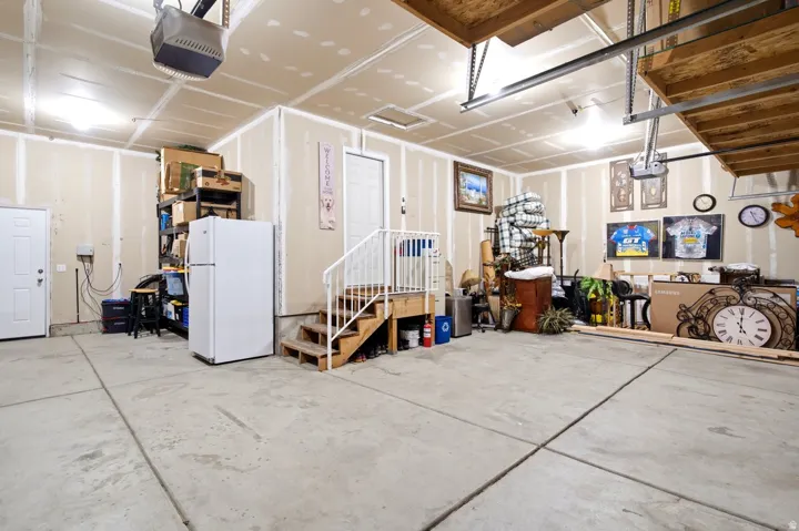 Spacious garage with concrete flooring, over head storage and extra deep 3 car garage.