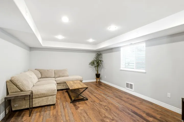 Spacious room featuring wood-finish flooring, recessed lighting, and a window with blinds