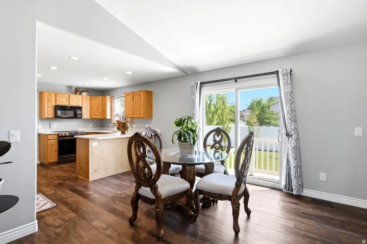 Open-concept dining area featuring wood-finish flooring, a sliding glass door to the exterior, and recessed lighting