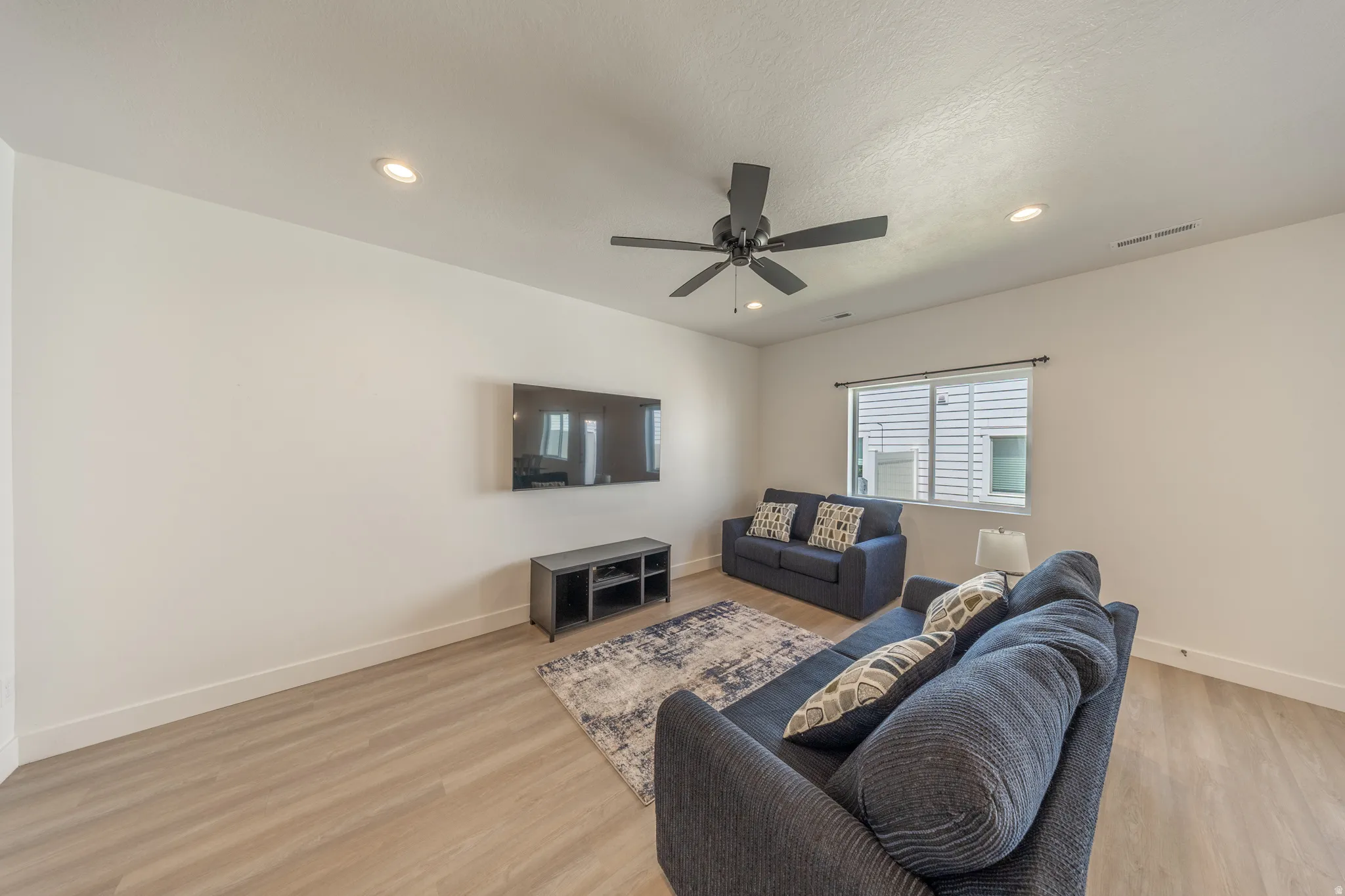 Living area featuring light wood-finish flooring and white walls