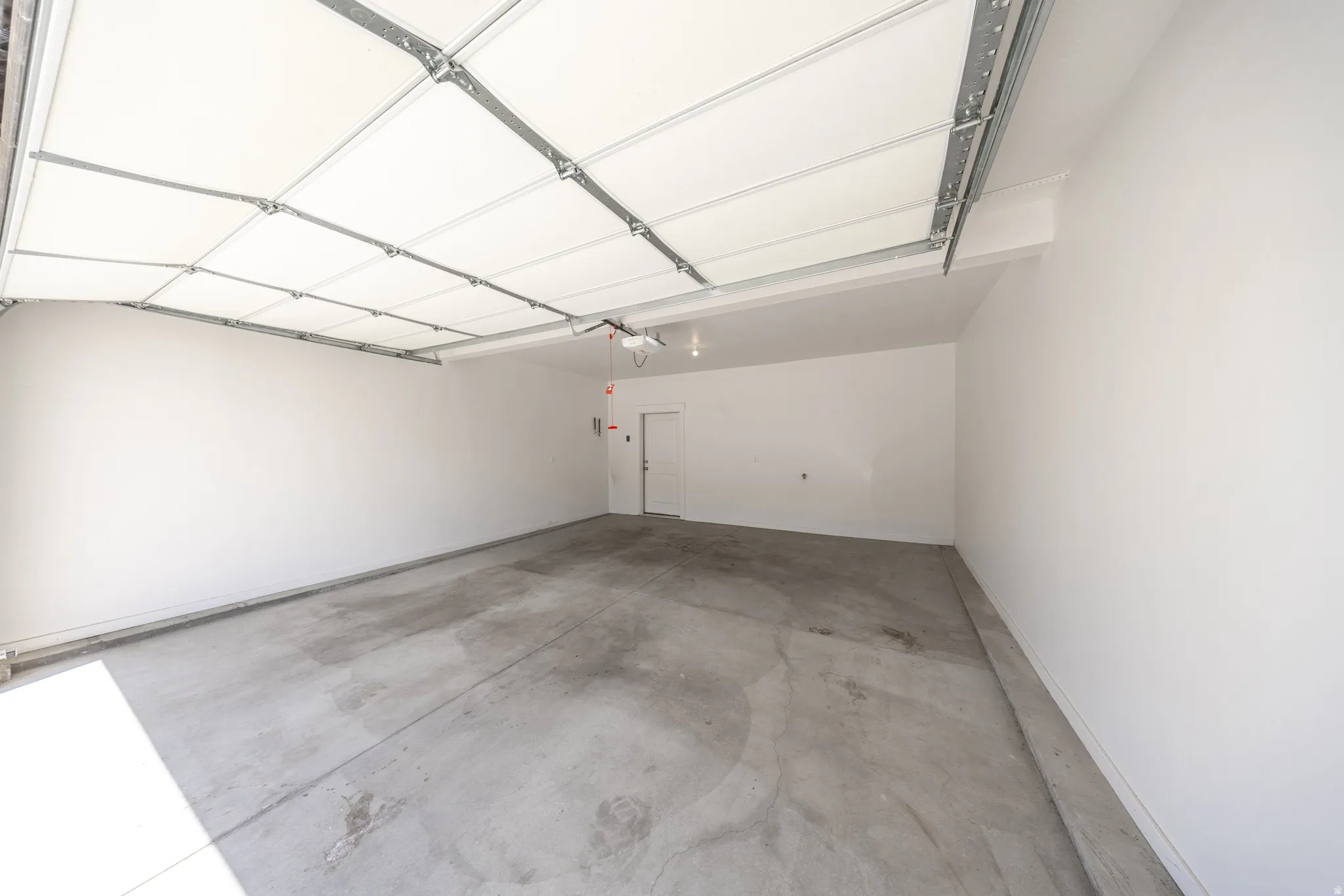 Spacious garage featuring a concrete floor, painted white walls, and insulated garage door