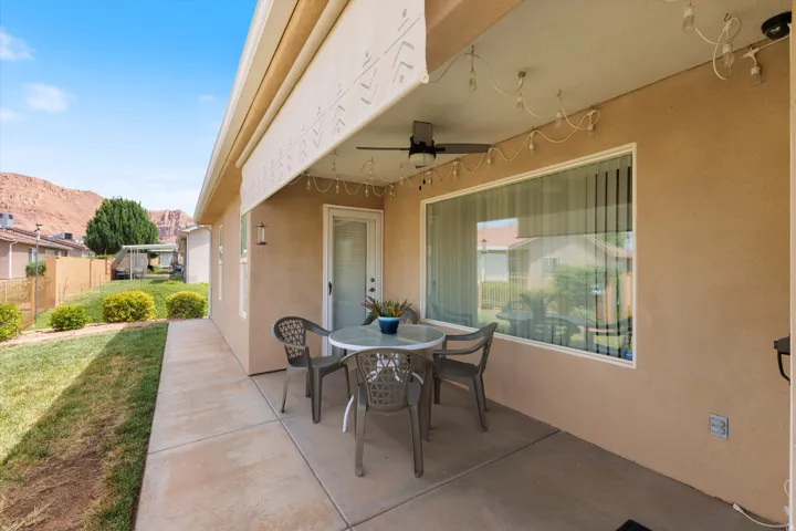 Covered concrete patio featuring a ceiling fan and outdoor lighting