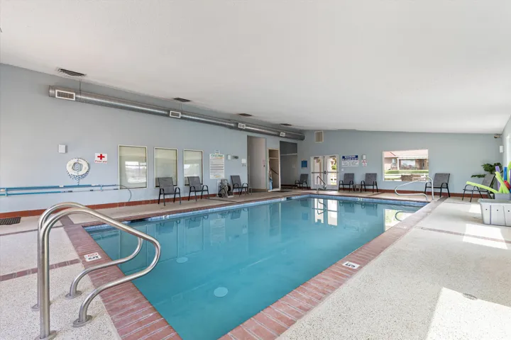 Indoor swimming pool featuring light blue walls and a white ceiling
