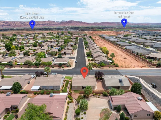 Aerial perspective showcasing a residential neighborhood with surrounding desert landscape and distant red rock formations