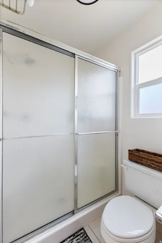 Shower enclosure featuring frosted sliding glass doors and a chrome frame