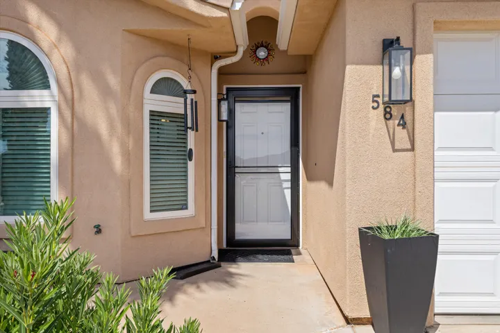 Stucco exterior featuring arched windows with horizontal blinds and white framing