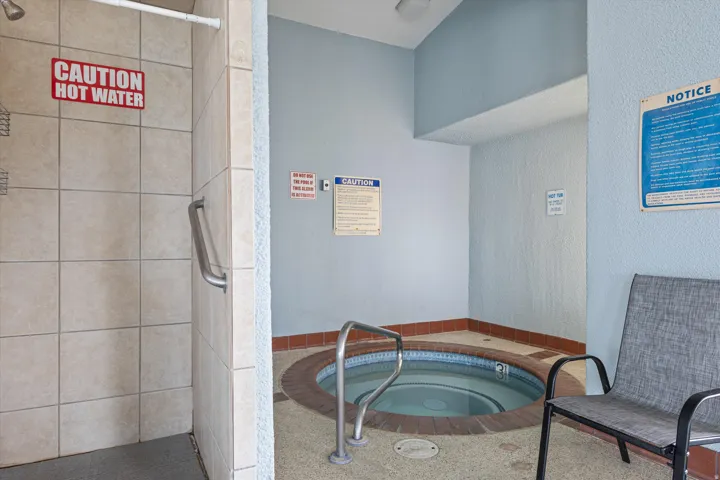 Indoor hot tub with tiled surround and metal grab rail