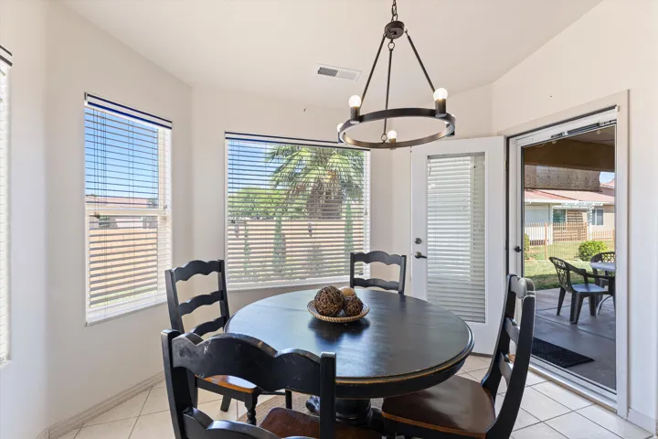 Dining area featuring multiple windows with blinds, a direct access French door, and tile flooring