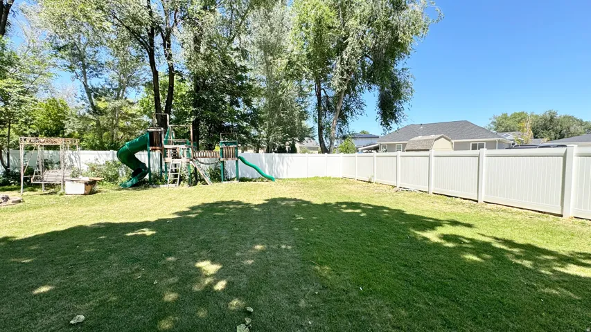 Expansive lawn area featuring a full privacy fence
