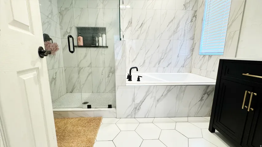 Bathroom featuring a built-in soaking tub and a walk-in shower with clear glass enclosure