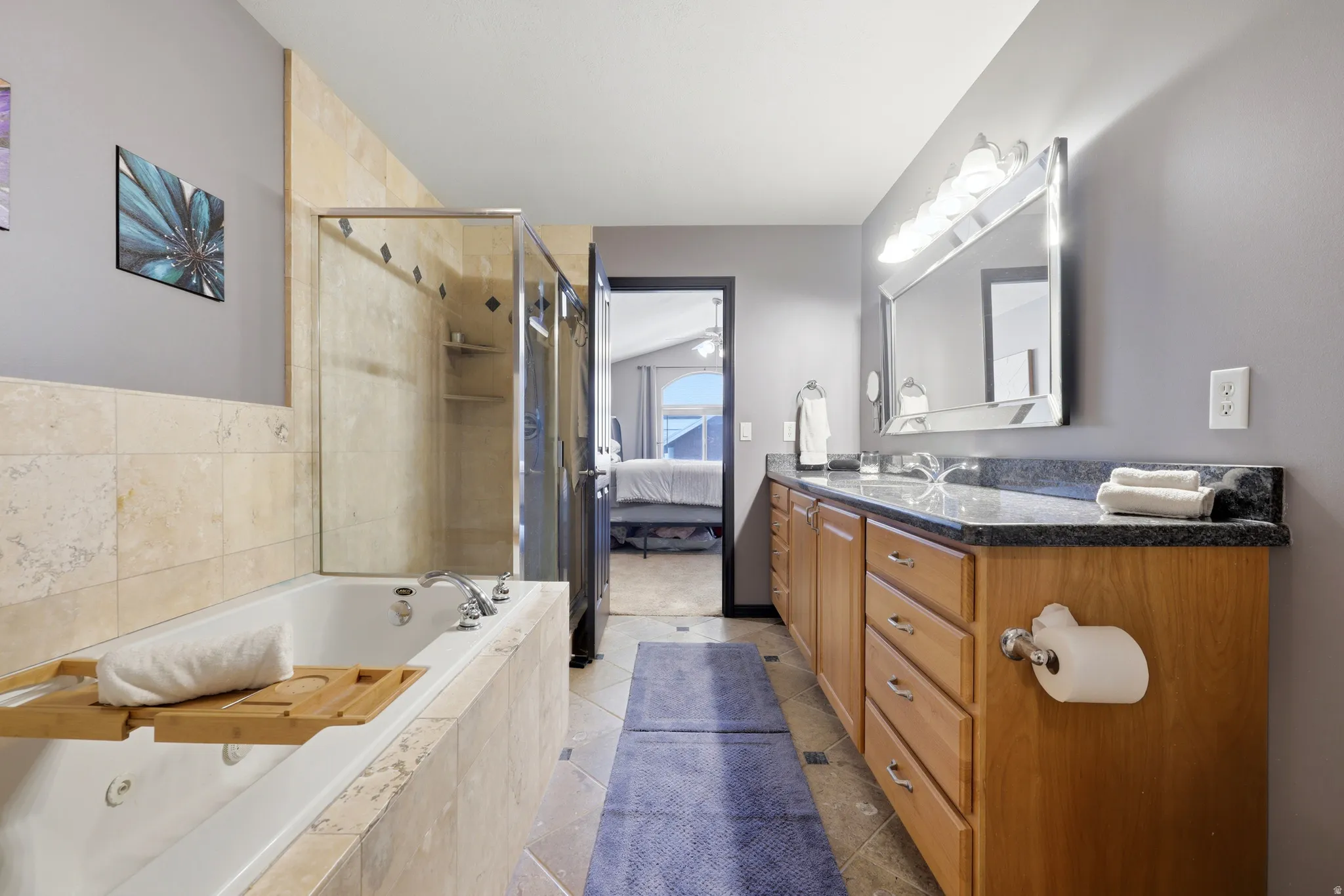 Dual vanity featuring a granite countertop and wood-finish cabinetry