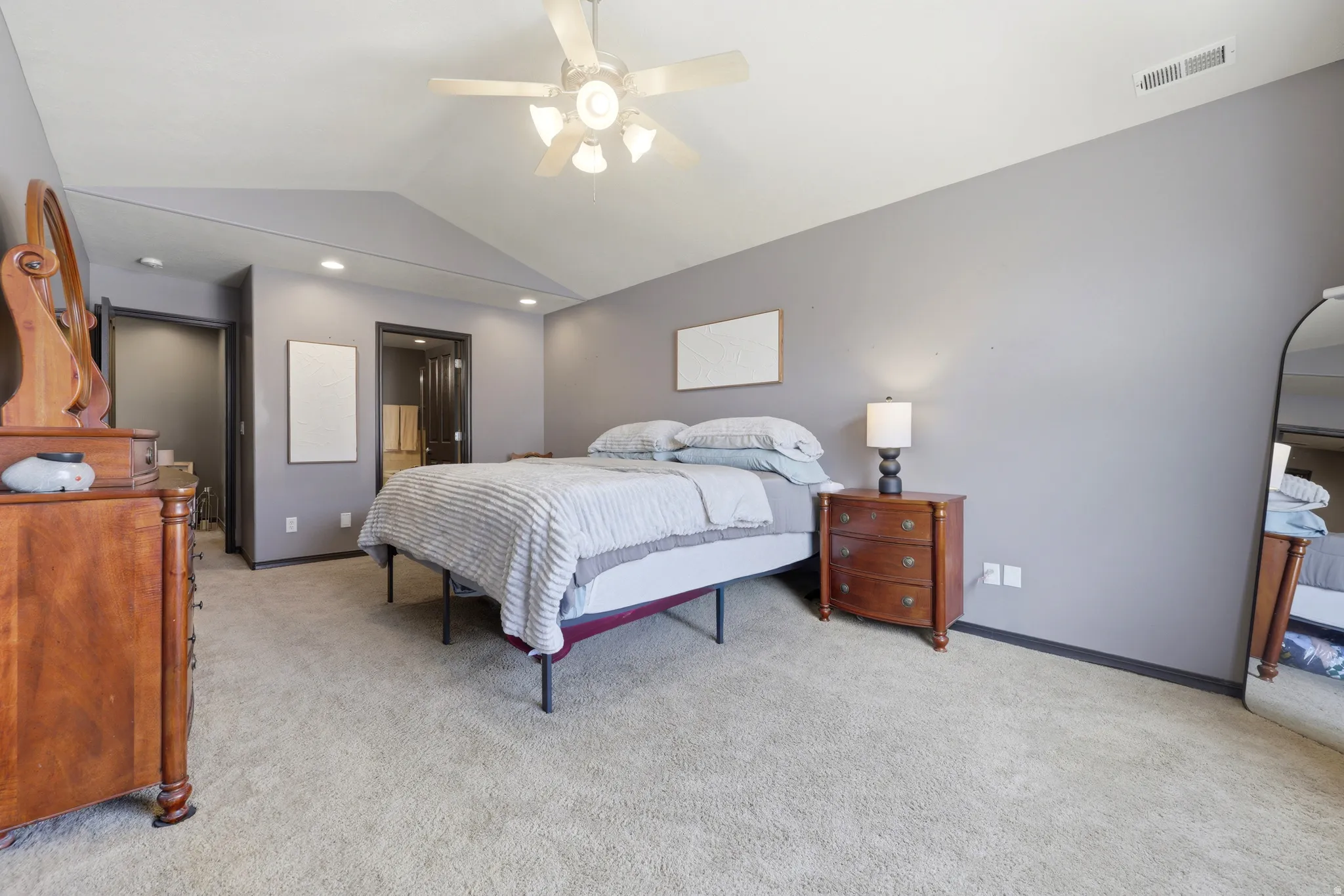 Carpeted room featuring a vaulted ceiling with a ceiling fan, recessed lighting, and a neutral wall color