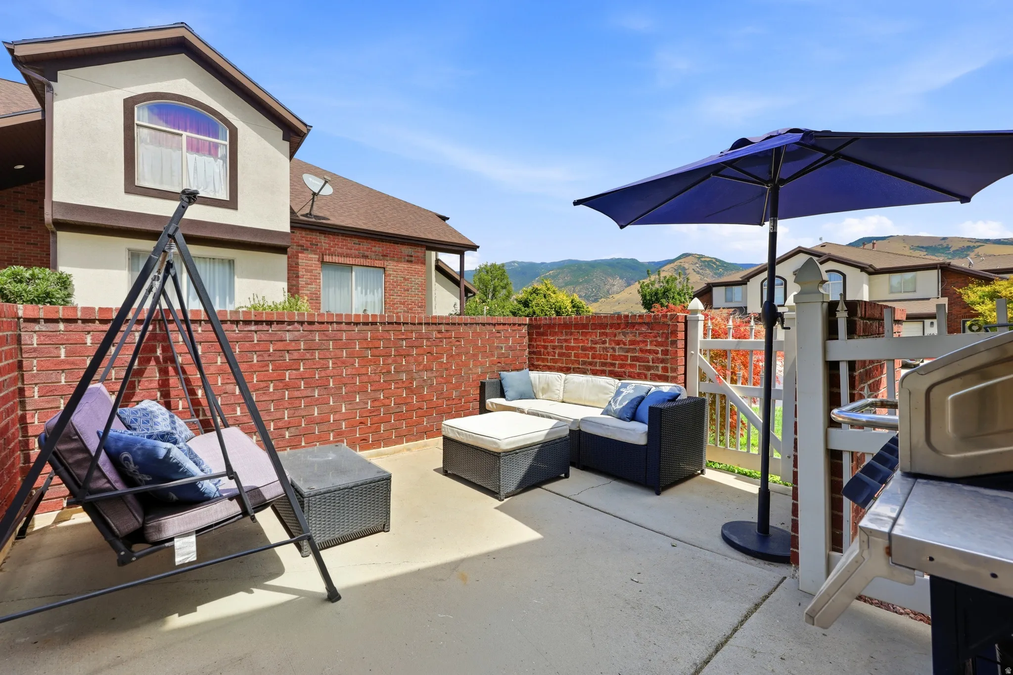 Private outdoor patio featuring a brick privacy wall and concrete surfacing