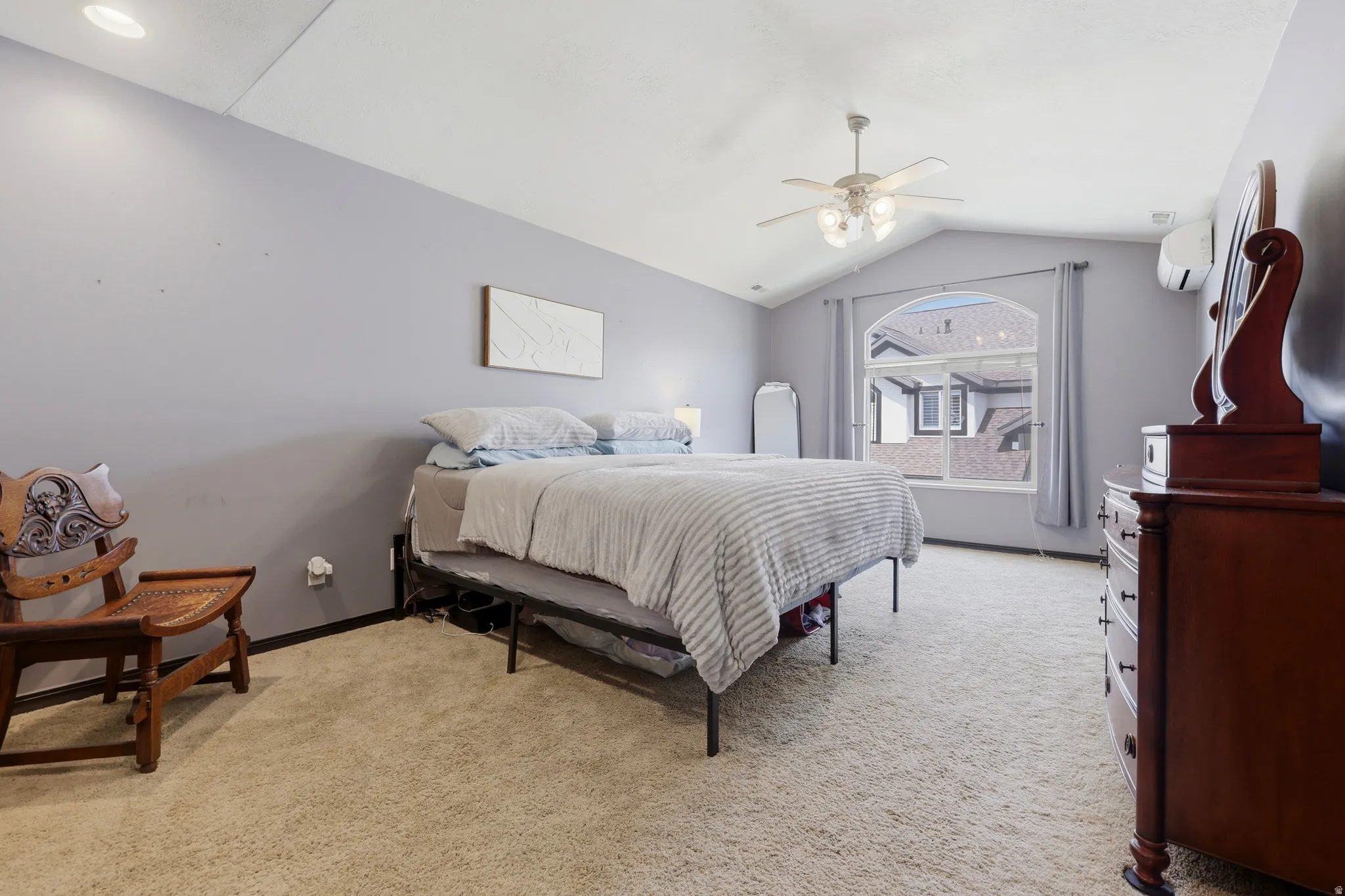 Carpeted room featuring a vaulted ceiling with a ceiling fan, recessed lighting, and an arched window