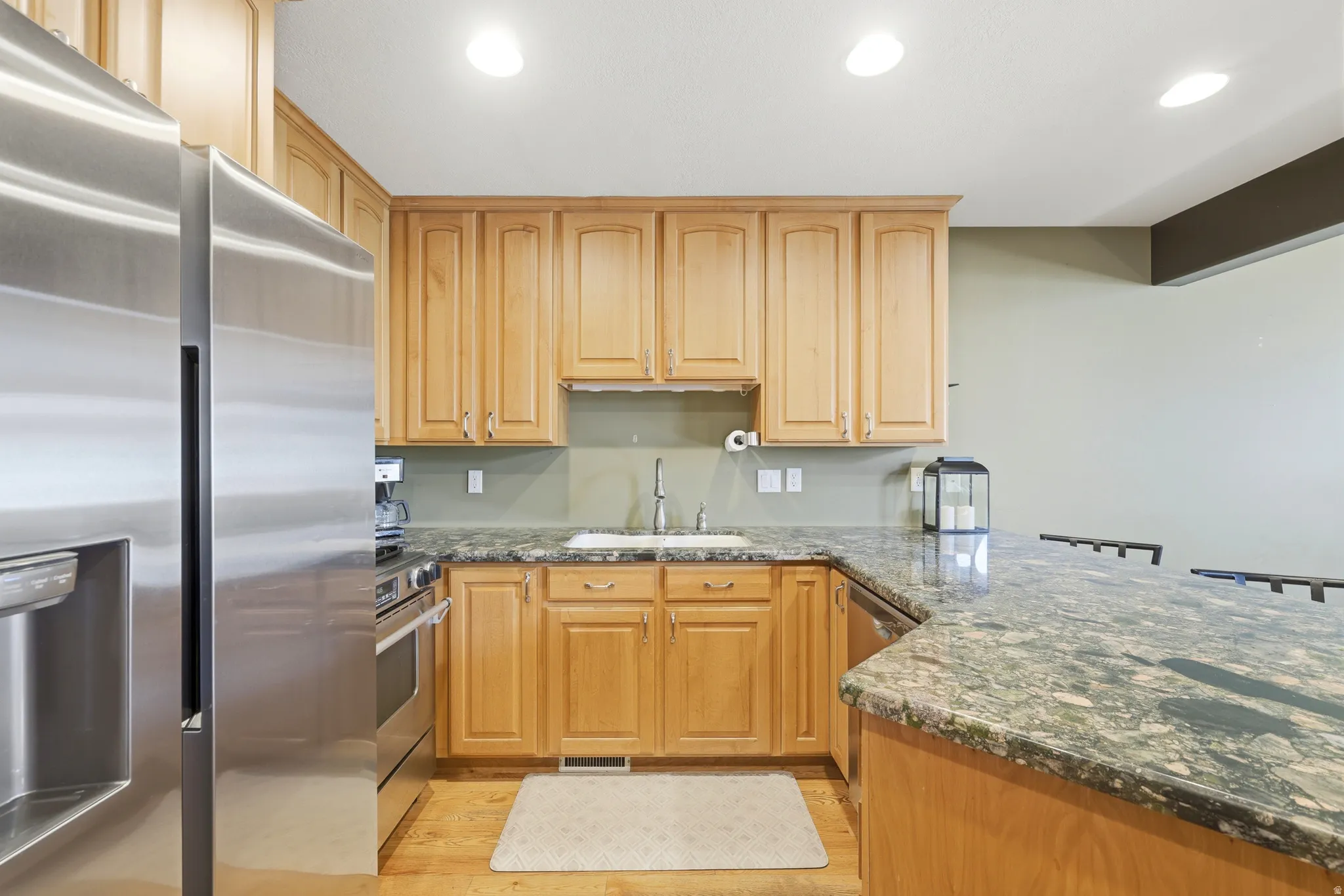 Kitchen featuring wood cabinetry, stainless steel appliances, and granite countertops