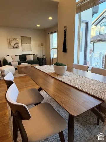 Dining area featuring wood-finish flooring, recessed lighting, and large windows with horizontal blinds