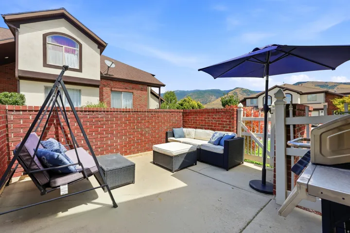 Private outdoor patio featuring a brick privacy wall and concrete surfacing