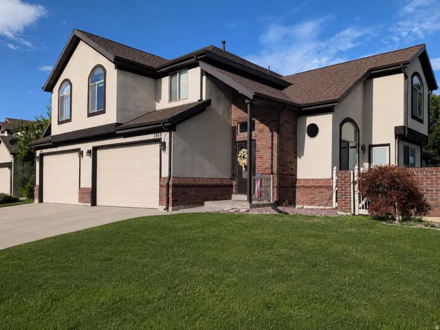 Stucco and brick exterior with a multi-level roofline