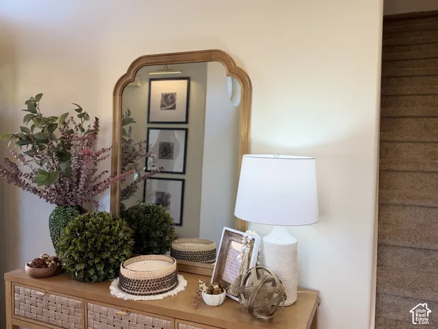 Arched wall mirror with a wood-toned frame and carpeted staircase
