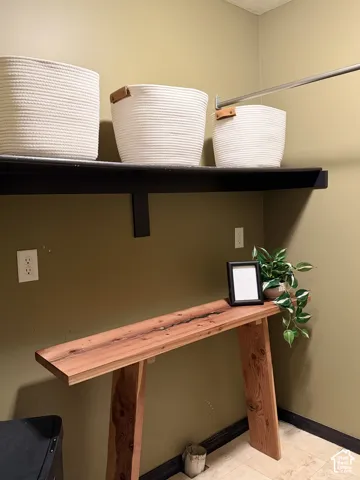 Wall-mounted horizontal shelving and a mounted metal rod providing overhead storage