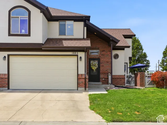 Modern facade featuring a two-car garage, brick accents, and a covered entry