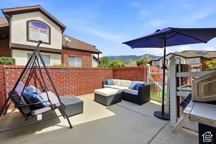 Private outdoor patio featuring a brick privacy wall and concrete surfacing