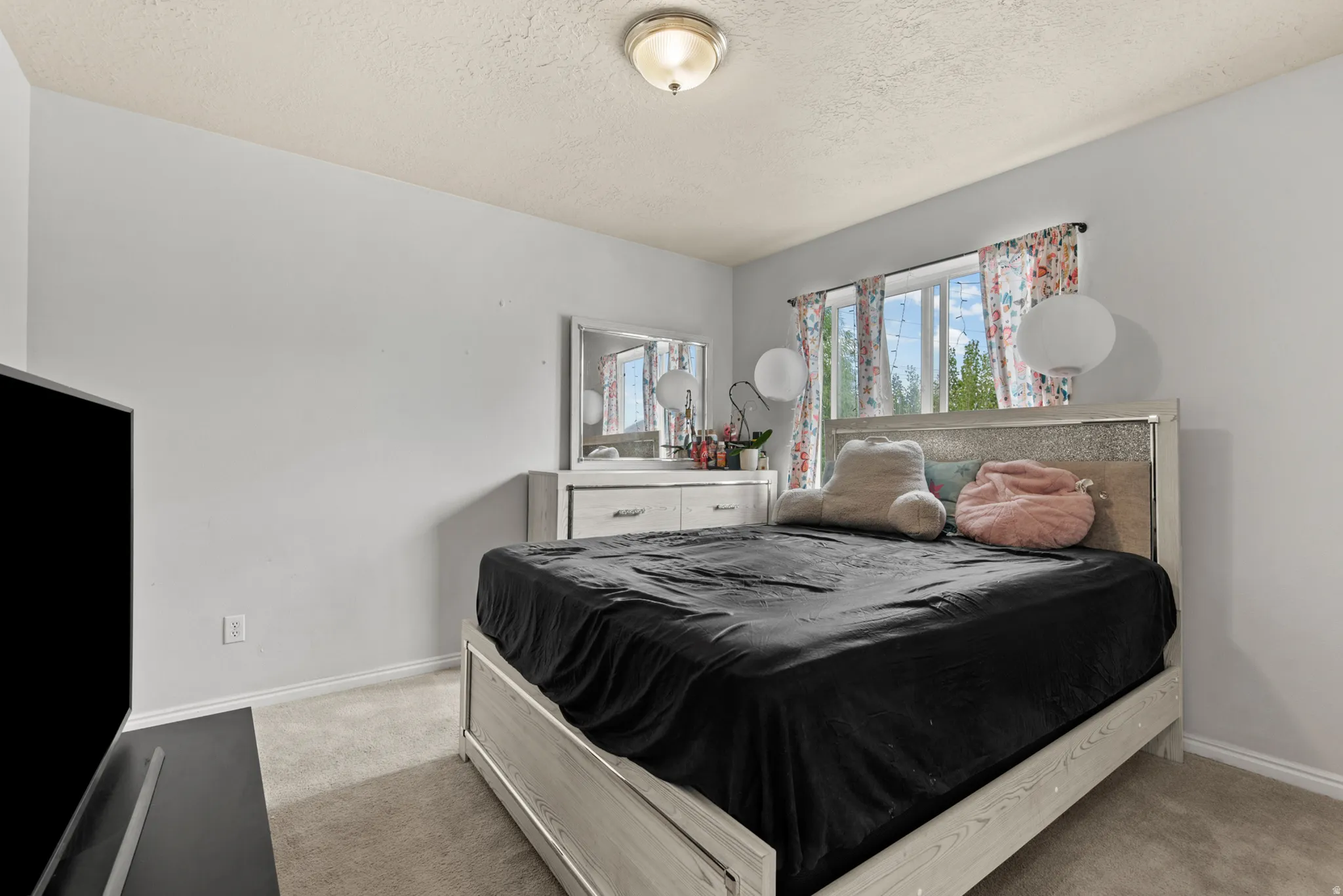 Carpeted bedroom with a built-in window and a ceiling-mounted light fixture