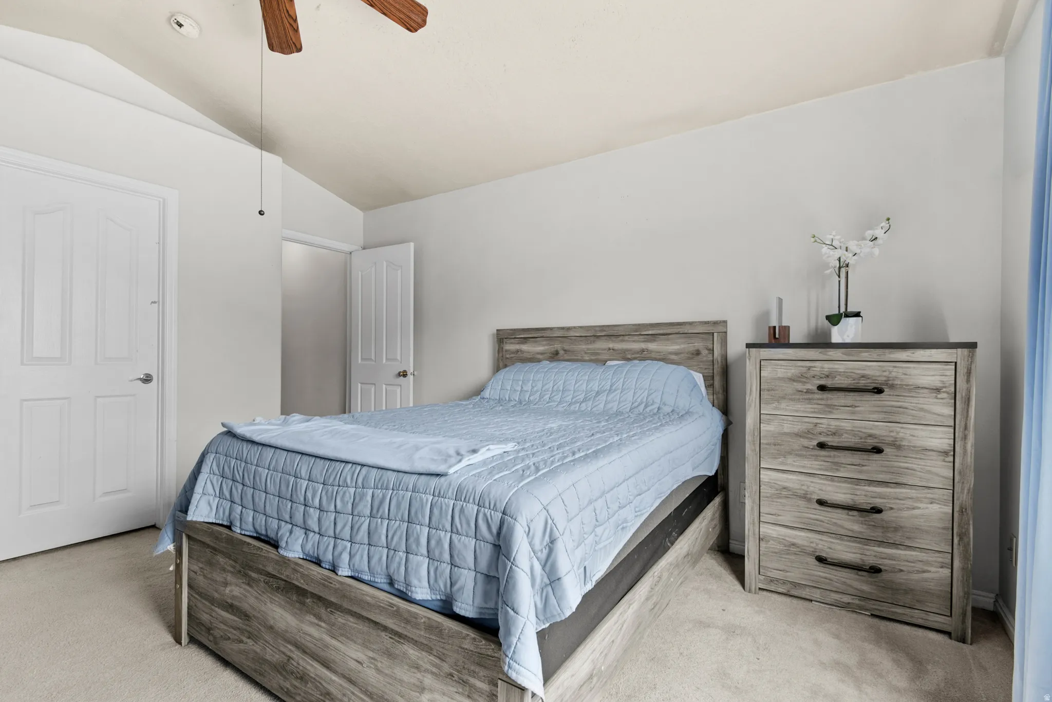 Bedroom featuring vaulted ceilings, carpet flooring, and a ceiling fan