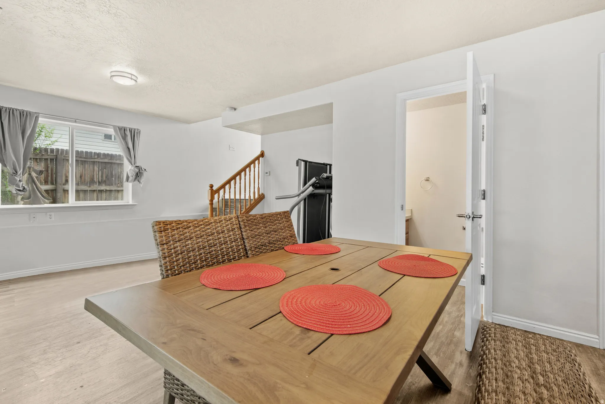 Brightly lit interior space featuring light wood-finish flooring and white painted walls