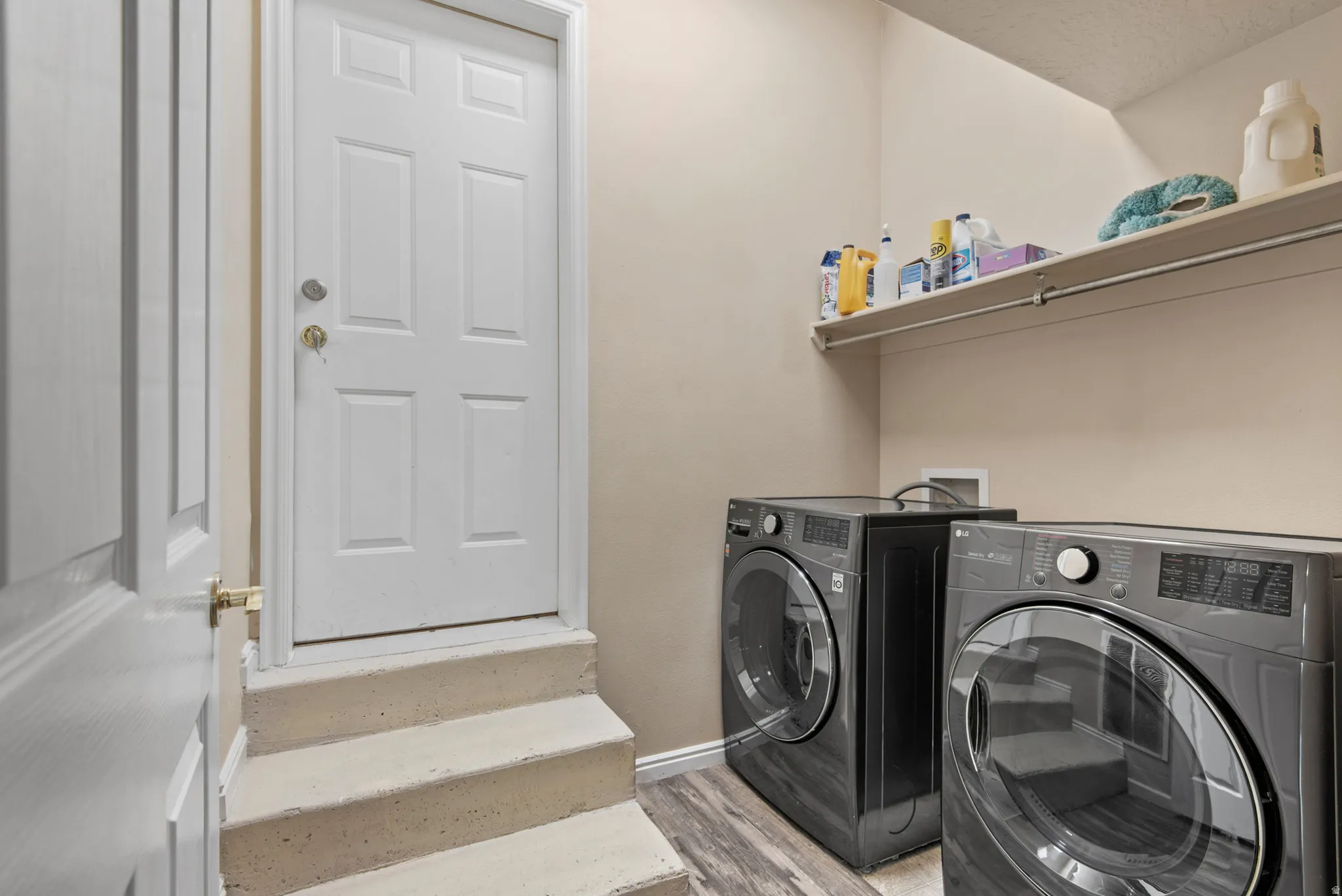 Dedicated laundry area featuring wood-finish flooring and neutral wall tones