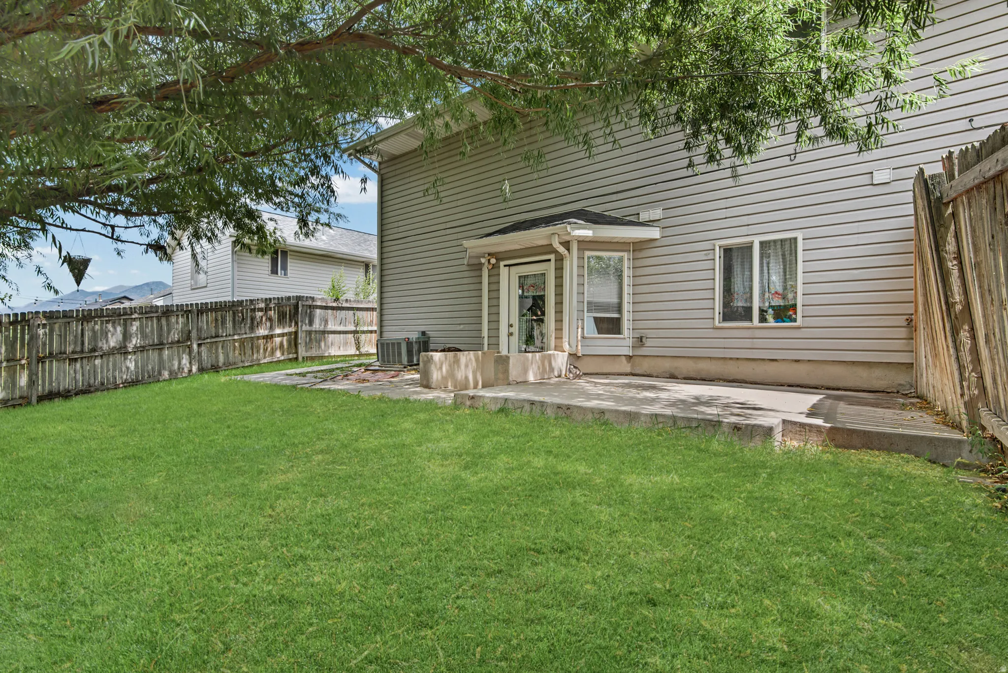 Expansive green lawn with a wood fence perimeter