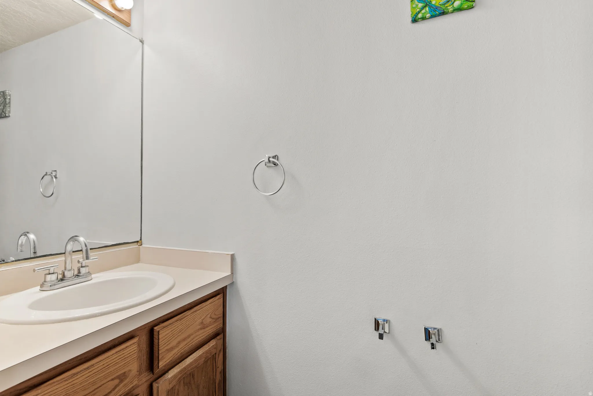 Bathroom vanity with wood-finish cabinetry, a built-in sink, and laminate countertop