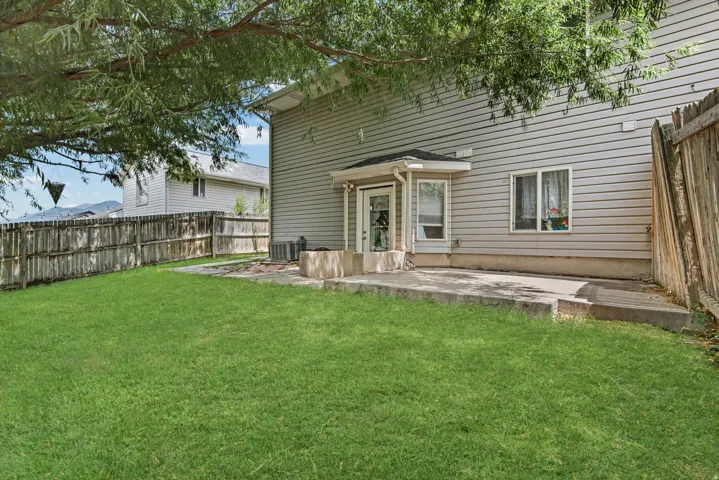 Expansive green lawn with a wood fence perimeter