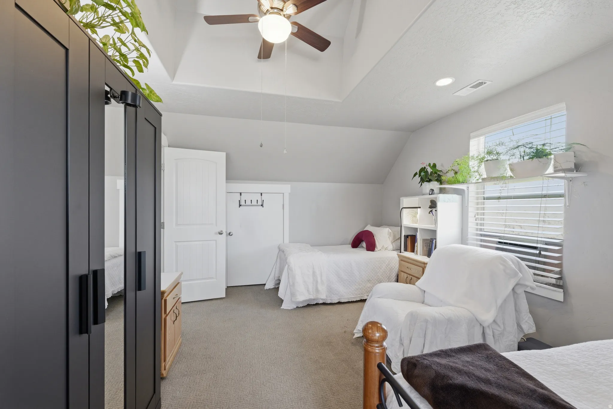 Bright room with sloped ceilings and a ceiling fan light fixture