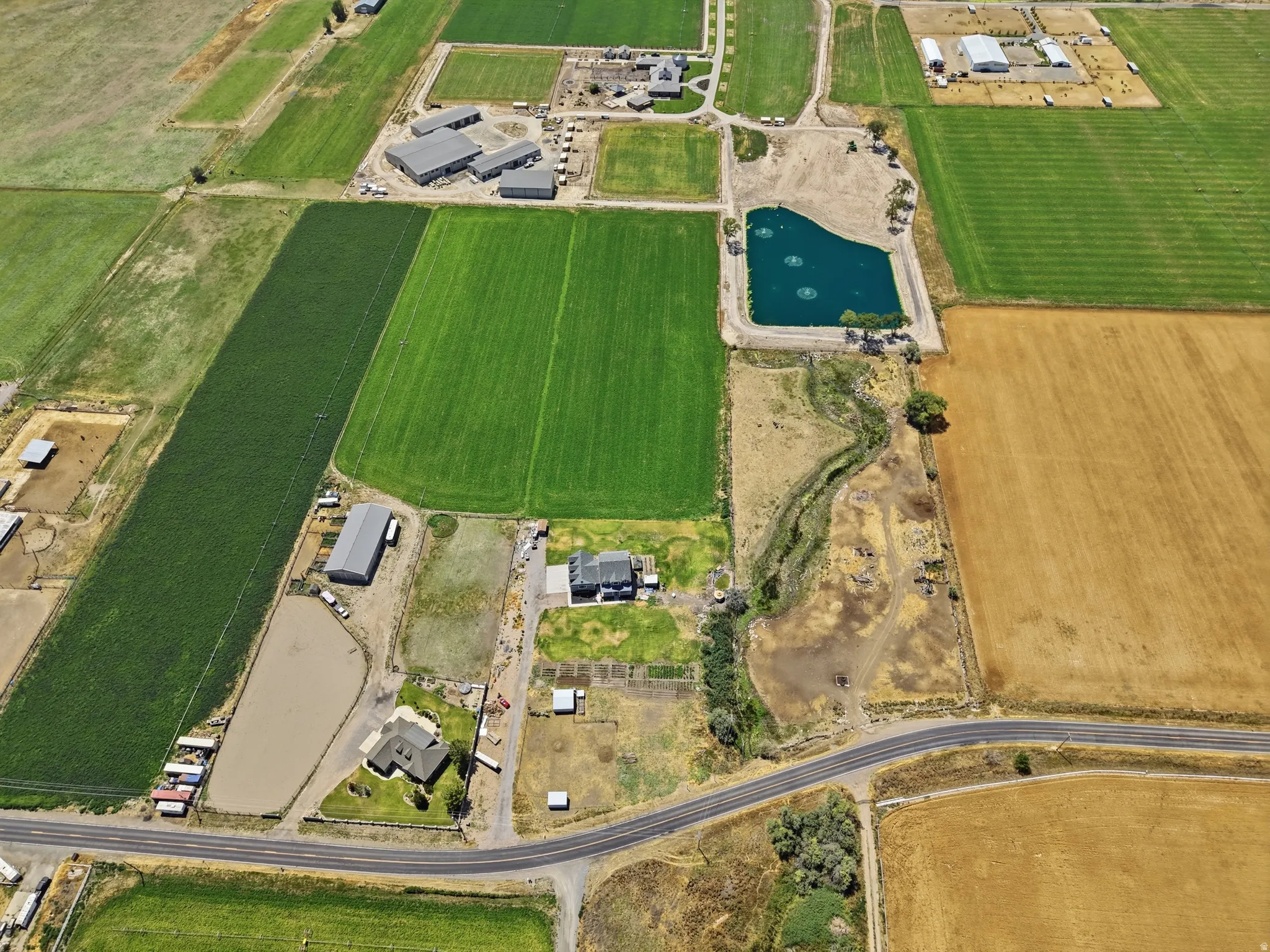 Expansive agricultural property showing the ponds, river, and green fields surrounding the home.