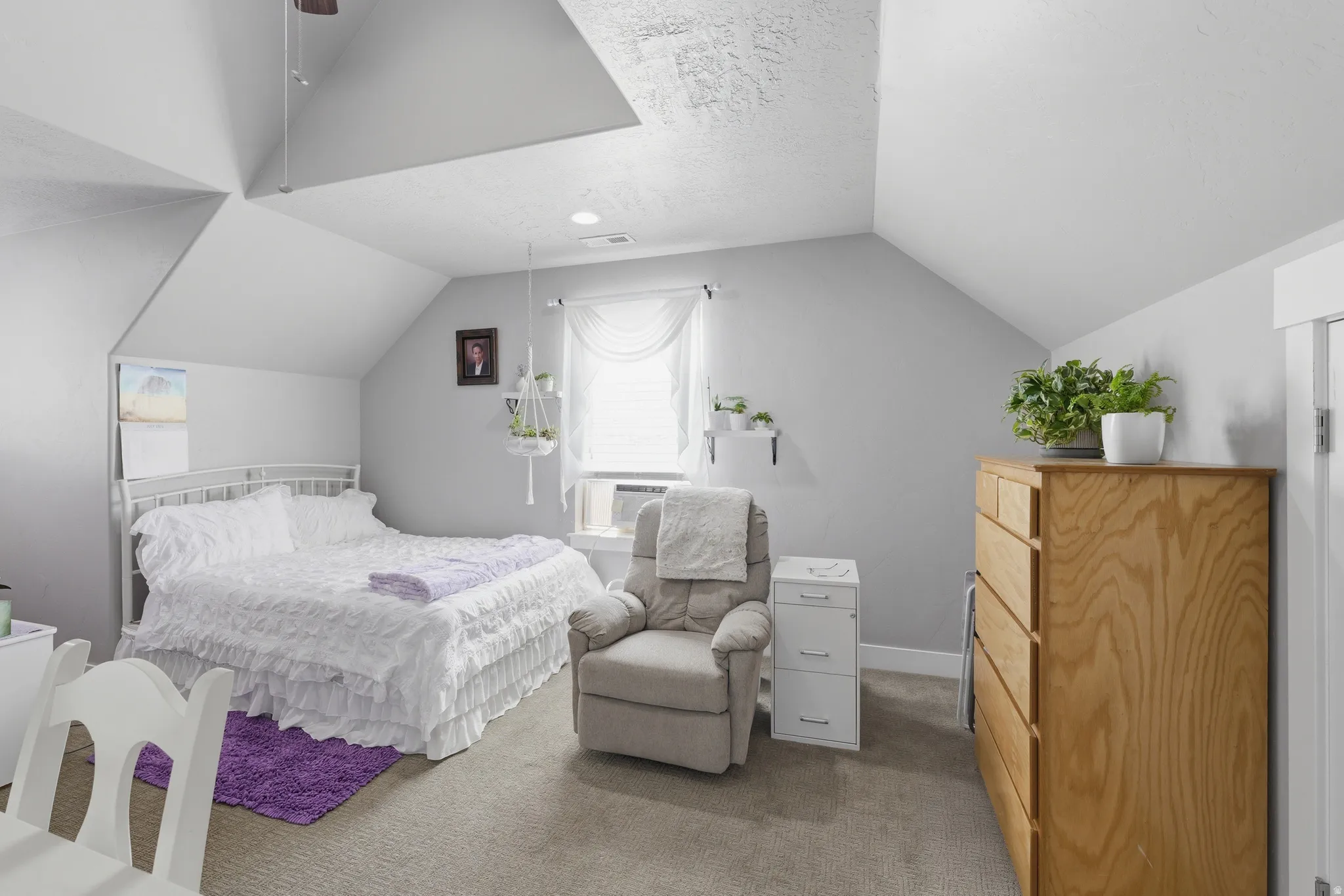 Vaulted ceiling room featuring carpet flooring and light gray painted walls