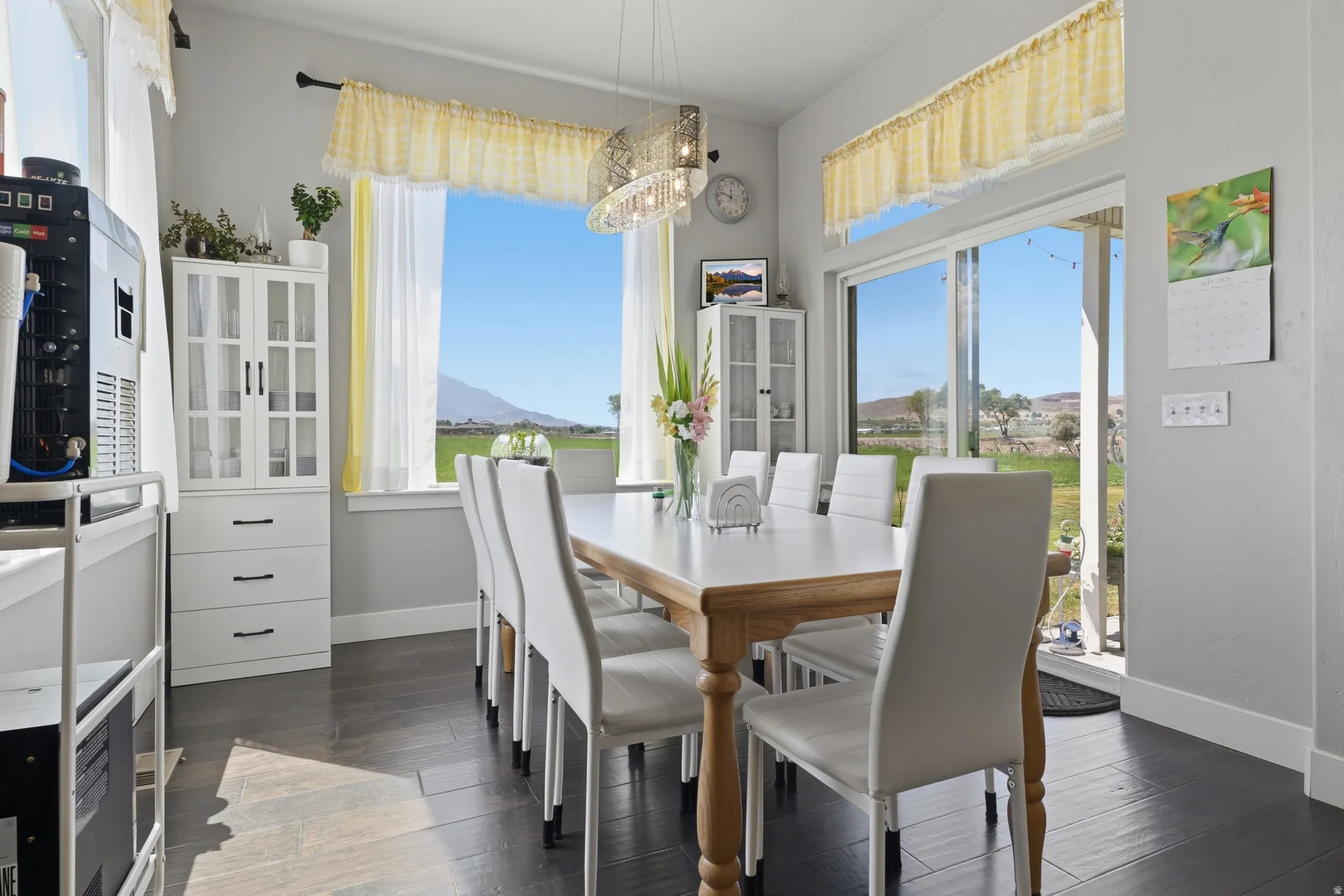 Dining area featuring dark wood-finish flooring, a contemporary light fixture, and white built-in cabinetry