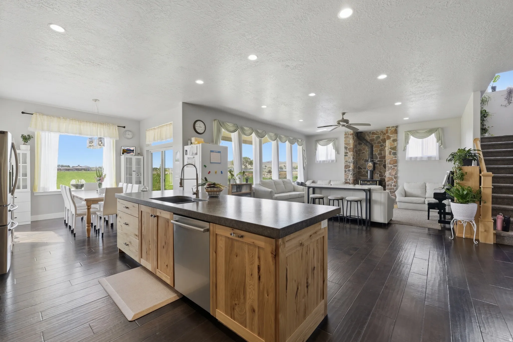 Expansive open-concept living area featuring dark wood-finish flooring