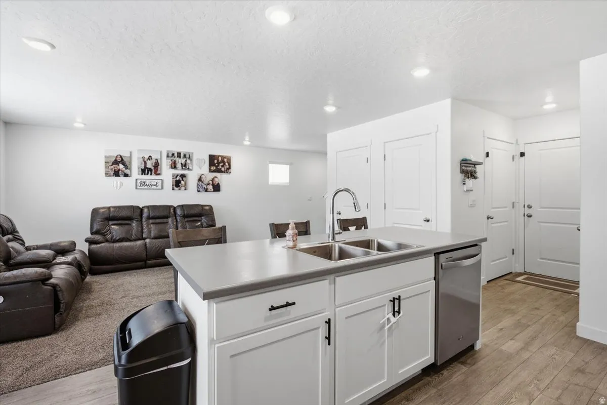 Kitchen island with a double basin stainless steel sink, a chrome gooseneck faucet, and a stainless steel dishwasher