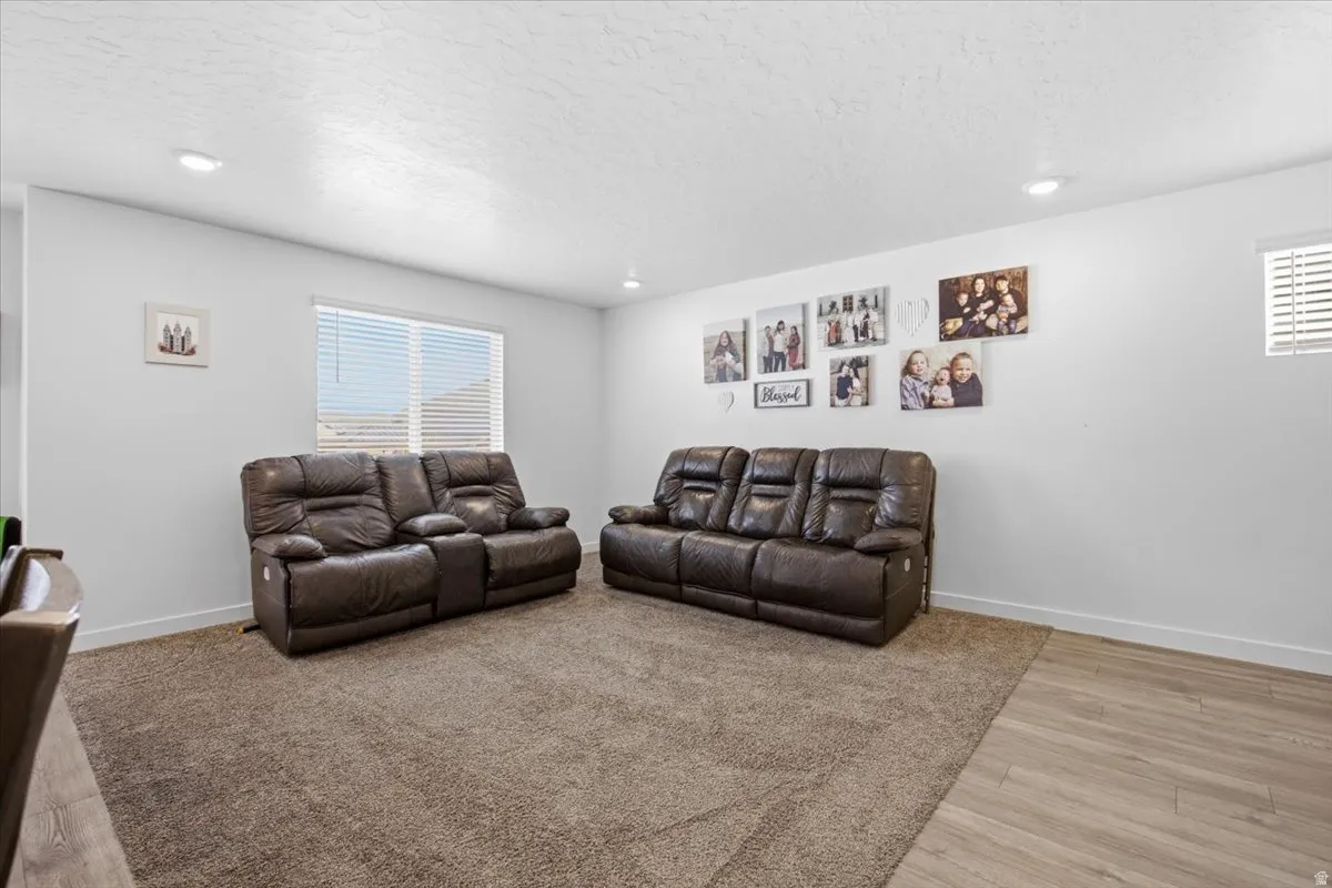 Spacious room featuring neutral carpet flooring and a partial section of wood-finish flooring