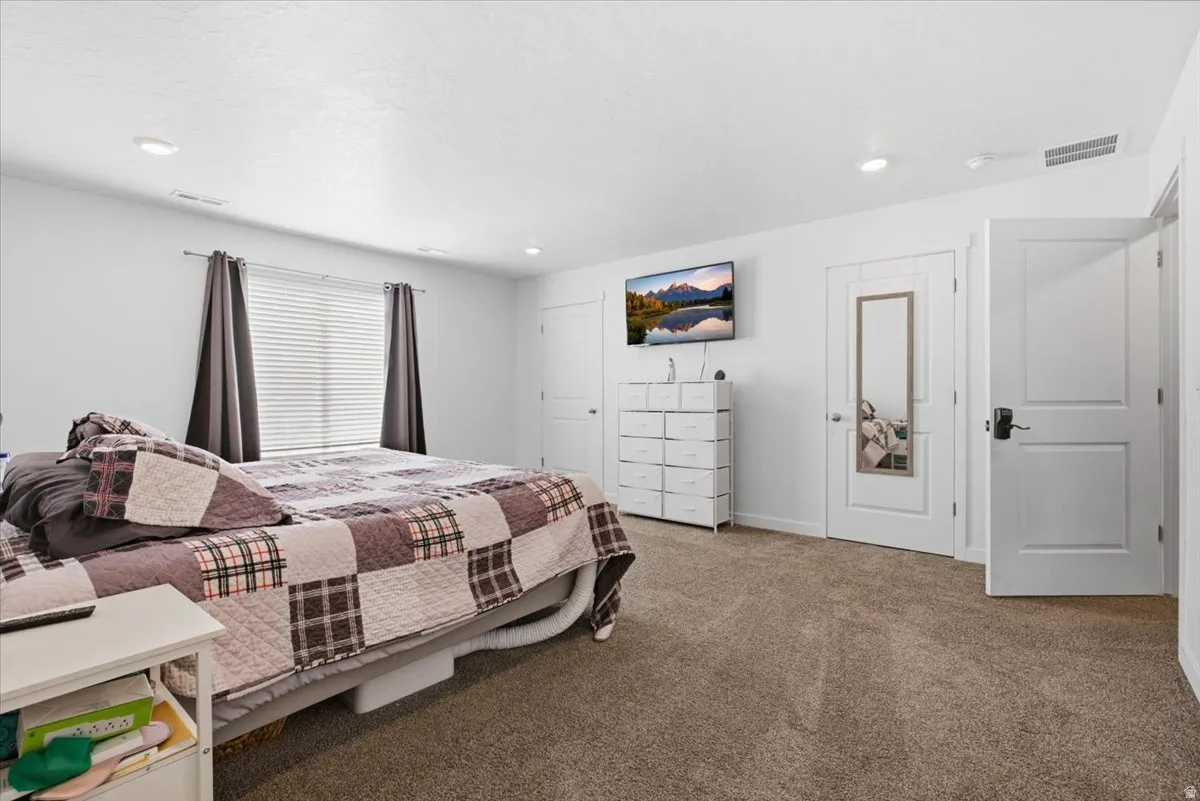 Neutral-toned carpeting extends throughout the room, complemented by white walls and trim