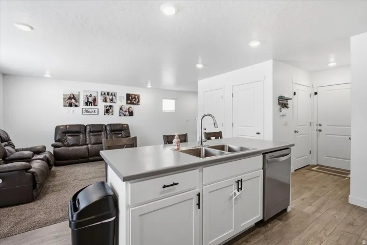 Kitchen island with a double basin stainless steel sink, a chrome gooseneck faucet, and a stainless steel dishwasher