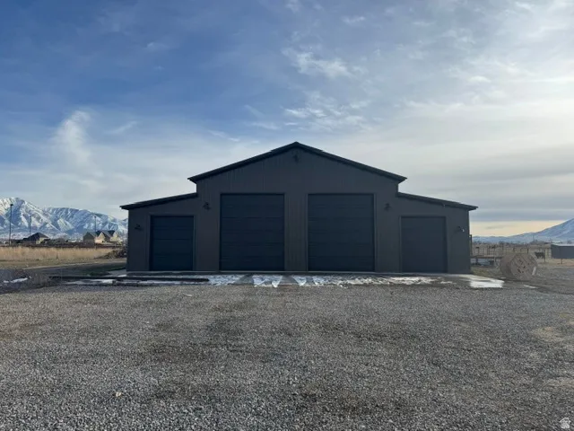 Metal-sided structure featuring three rollup doors and exterior lighting fixtures