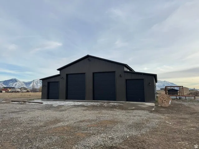Modern barn-style structure featuring vertical dark siding and a contrasting black pitched roof