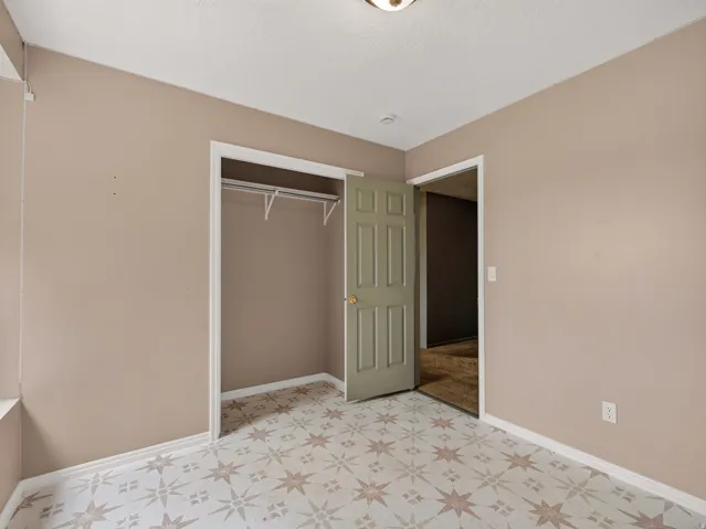 Room featuring neutral-toned walls and patterned floor tiling